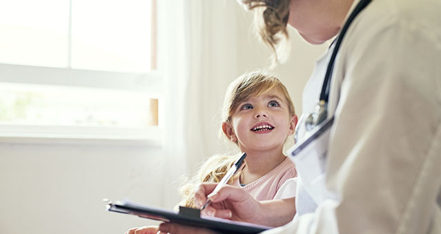  Doctor having a consultation with a little girl in her consulting room