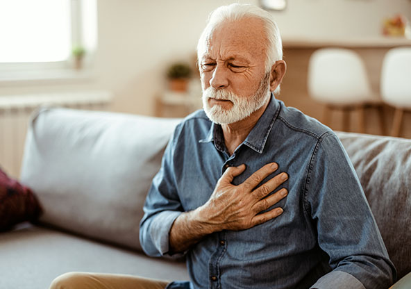 A man clutching his chest at home