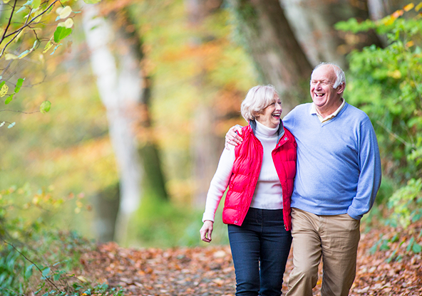 A senior couple walking in the  woods